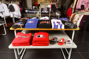 Champion品牌服裝和鞋子陳列在零售店的展示桌上。 — 冠軍 壁紙