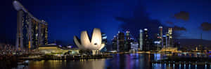 夜晚的新加坡天際線，燈火通明的建築物和海濱倒影。 — 夜晚 壁紙