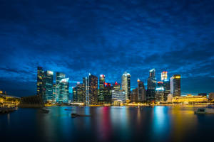 夜晚的新加坡天際線，發光的建築物倒映在水中。 — 夜景城市 壁紙