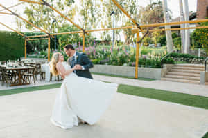 新娘和新郎在日落時分於花園婚禮中在木製涼亭下跳舞。 — 婚禮 壁紙
