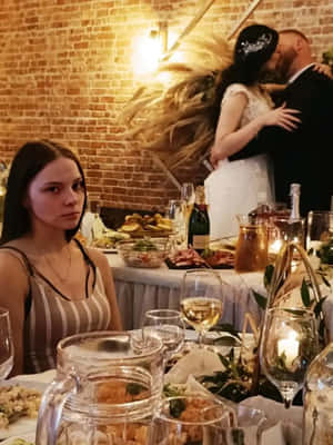 新娘和新郎熱情接吻，而一名女子在晚餐桌上看著。 — 婚禮 壁紙