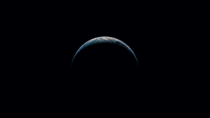 從太空看到的新月形地球，在黑色虛空中閃耀著城市燈光。 — 美學 Mac 壁紙