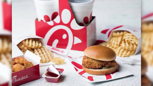 Chick-fil-A雞肉三明治、格子薯條和雞塊放在品牌托盤上。 — 一個 壁紙