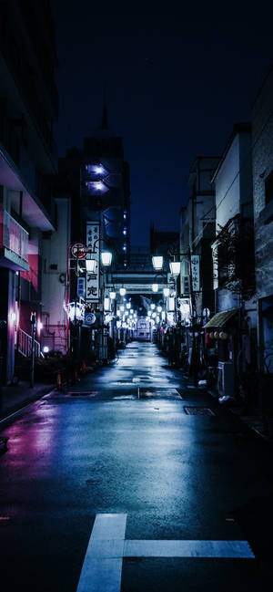 日本雨夜的街道，被發光的燈籠和霓虹燈招牌照亮。 — iPhone 15 Pro 壁紙