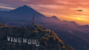 日落時山丘上的Vinewood標誌，飛機飛過上空。 — 日落 壁紙