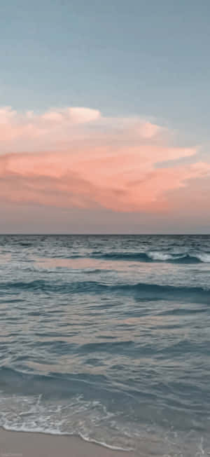 日落時分的海浪，粉紅雲彩倒映在水面上。 — Galaxy S24 FE 壁紙