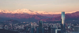 日落時分白雪覆蓋的山峰閃耀的城市天際線。 — 布宜諾斯艾利斯 壁紙