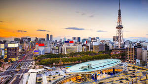 日落時分的東京城市景觀， featuring 東京塔和發光的建築物。 — 京都 壁紙