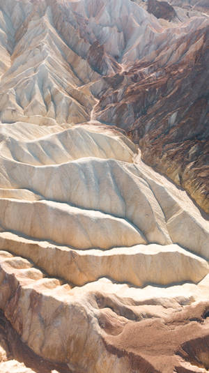強烈陽光下，帶有層狀砂岩結構的脊狀沙漠峽谷。 — 山坡 壁紙
