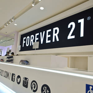 Forever 21店面，帶有社交媒體圖標和明亮燈光。 — 永遠21 壁紙