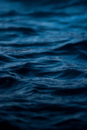 夜間燈光下深藍色海浪泛起漣漪。 — 榮耀MagicPad 3 壁紙