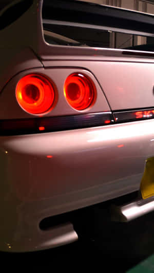 夜間銀色跑車帶有發光紅色尾燈。 — 粉紅色 壁紙