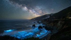 在繁星點點的夜空下，生物發光的波浪拍打著黑暗的懸崖。 — macOS Big Sur 動態桌布 壁紙