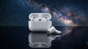 白色耳機及充電盒在深色表面上帶有銀河反射。 — AirPods 壁紙