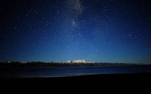 星空之夜，銀河在積雪的山峰和寧靜的湖泊之上。 — 天空景色 壁紙