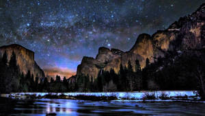 星空下白雪覆蓋的山脈，下方是發光的河流。 — 星星 壁紙
