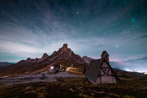 星空下，山腳下的小教堂和小屋。
