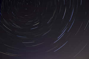 長時間曝光攝影下，夜空中旋轉的星軌。 — 黑色星球 壁紙