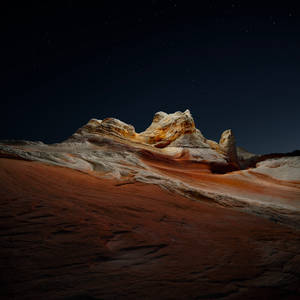 紅色砂岩岩層上的星空之夜，帶有橙色和白色的條紋。 — 美學 Mac 壁紙