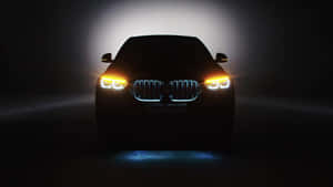 BMW SUV 正面視圖，在黑暗中車頭燈和進氣格柵發光。 — 最佳黑暗 壁紙