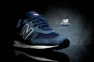 深藍色 New Balance 1300NR 運動鞋，白色標誌，在煙霧瀰漫的攝影棚燈光下，反射表面上。 — 美學深藍 壁紙