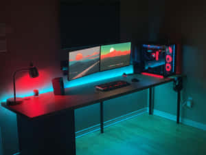 在彩色LED燈光下，配備雙顯示器和發光PC的遊戲設置。 — PC 遊戲 壁紙