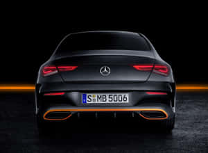 黑色 Mercedes-Benz CLA 後視圖，帶有發光尾燈和橙色排氣飾條。 — Mercedes Benz C300 壁紙