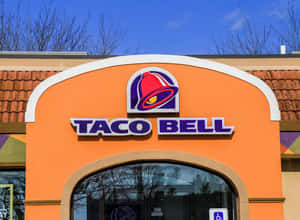 Taco Bell餐廳入口，橙色牆壁配藍天背景。 — 塔可 壁紙