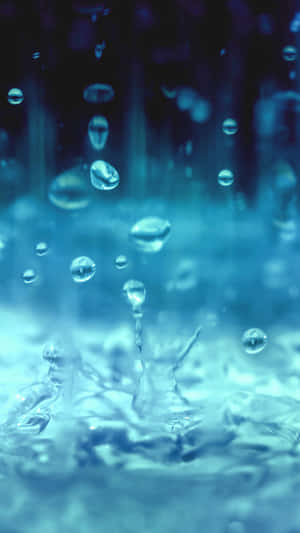 水滴在冷藍色調中落下並飛濺的特寫。 — 透明 壁紙