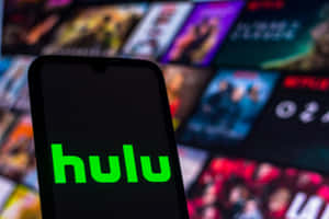 智慧型手機顯示Hulu應用程式標誌，背景有串流服務縮圖。 — 葫蘆 壁紙