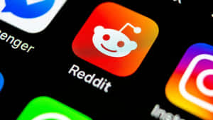 智慧型手機螢幕上Reddit應用程式圖示的特寫，帶有彩色漸變。 — AMOLED 壁紙