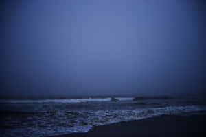 深藍色的海浪在黃昏時分湧向霧濛濛的海灘。 — 黑夜 壁紙