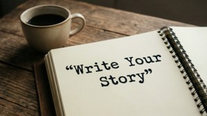 木桌上的咖啡杯和帶有「Write Your Story」文字的筆記本。 — 激勵 壁紙