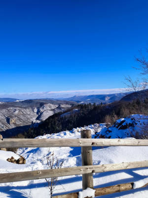 在晴朗的冬日，從木柵後面看到的雪山景觀。 — 安卡拉 壁紙