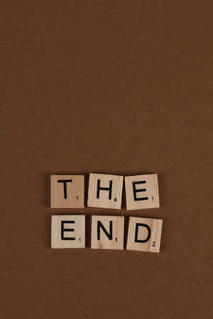 木製 Scrabble 字塊在棕色背景上拼出 the end — Huawei MatePad 11.5 S (2025) 壁紙