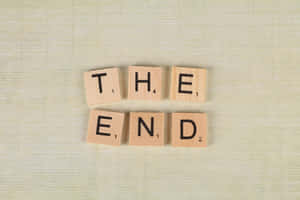 木製 Scrabble 字母牌在米色紋理背景上拼出 the end。 — 鄉村道路 壁紙