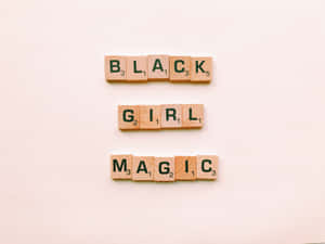 木製 Scrabble 字母磚排列在米色表面上拼出 Black Girl Magic。 — 黑色卡通女孩 壁紙