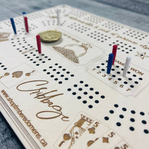 木製克里比奇棋盤，帶有彩色棋子和一枚硬幣在遊戲中。 — 藍白 壁紙