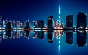 夜晚的杜拜天際線，摩天大樓倒映在平靜的水面上。 — 巴林 壁紙