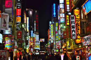 夜晚東京的霓虹燈街道，擁擠的人行道和發光的招牌。 — 城市燈光 壁紙