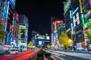東京夜晚一條閃爍霓虹燈的街道，帶有行駛車輛的光跡。 — 東京喰種風格 壁紙