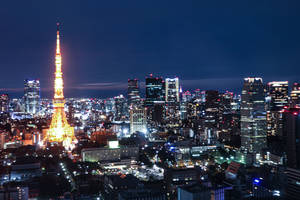 夜晚的東京鐵塔，背景中閃爍的城市燈光。 — 數碼 壁紙