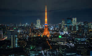 夜晚的東京鐵塔被點亮，周圍環繞著閃爍的城市燈光。 — 東京 壁紙