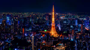 夜晚的東京鐵塔被點亮，周圍環繞著閃爍的城市燈光。 — 東京 壁紙