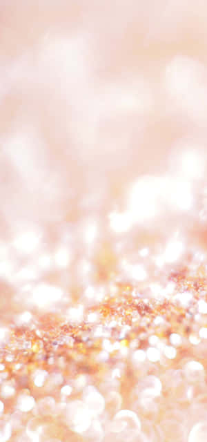 柔和發光的閃粉粒子，溫暖蜜桃和金色調，背景模糊。 — Galaxy S24 FE 壁紙