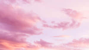 粉紅和蜜桃色雲彩在寧靜的暮色天空中飄移。 — 粉紅色美學桌面 壁紙