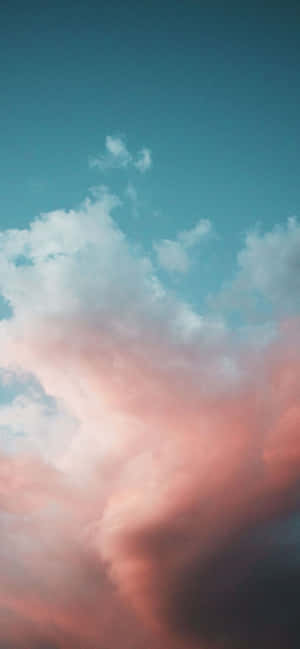 粉紅色和青綠色雲彩在寧靜的暮色天空中飄動。 — 1170x2532 壁紙