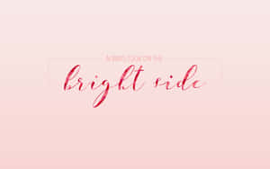 勵志名言always look on the bright side，以紅色草書寫在粉紅色漸變背景上。 — 勵志桌面 壁紙