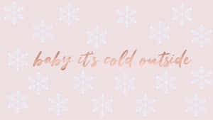 粉紅色背景，帶有白色雪花和玫瑰金色文字，寫著 baby it's cold outside。 — 聖誕美學 壁紙