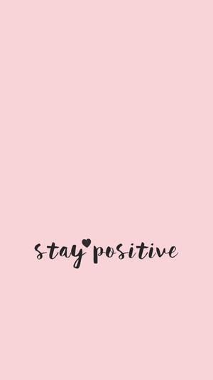 粉紅色背景，黑色草書文字寫著 stay positive，並附有心形。 — 粉紅色 壁紙